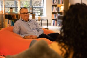 Robert Rackley MSc MIACP, neurodivergent psychotherapist, seated on a beanbag in his autism-friendly therapy room in Limerick, offering ADHD and autism therapy online and in person.