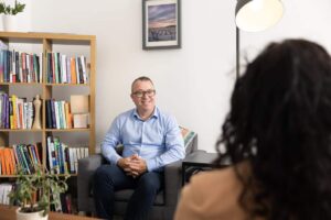 Neurodivergent psychotherapist Robert Rackley sitting with a client in his Limerick therapy room during a counselling session.